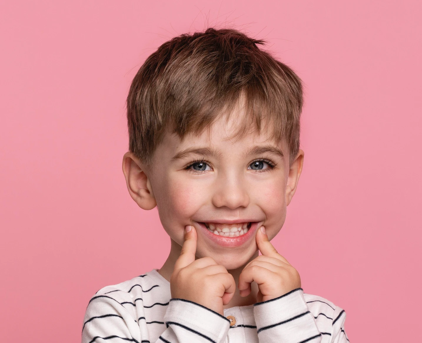 Child smiling for facial and dental coordination section